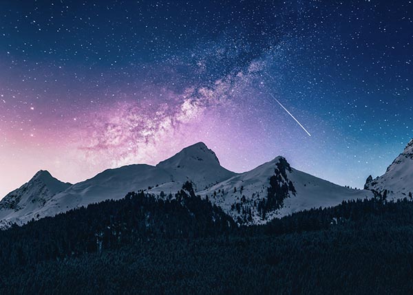 Mystisches Bild einer Landschaft, die Berge und einen Sternenhimmel zeigt