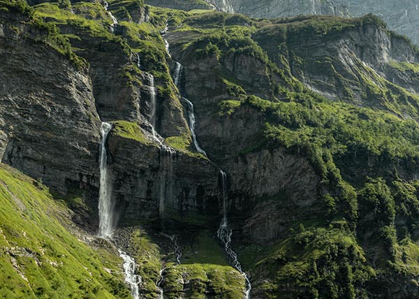 Eine grüne Berglandschaft mit einem Wasserfall