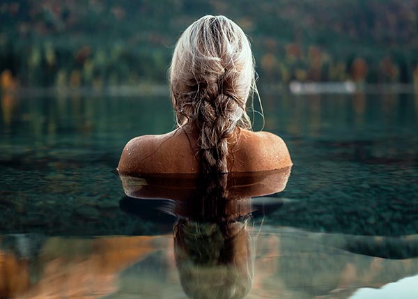 Blonde Frau badet im See
