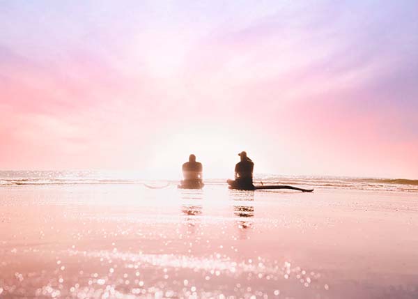 Zwei Personen im Meer bei Sonnenuntergang